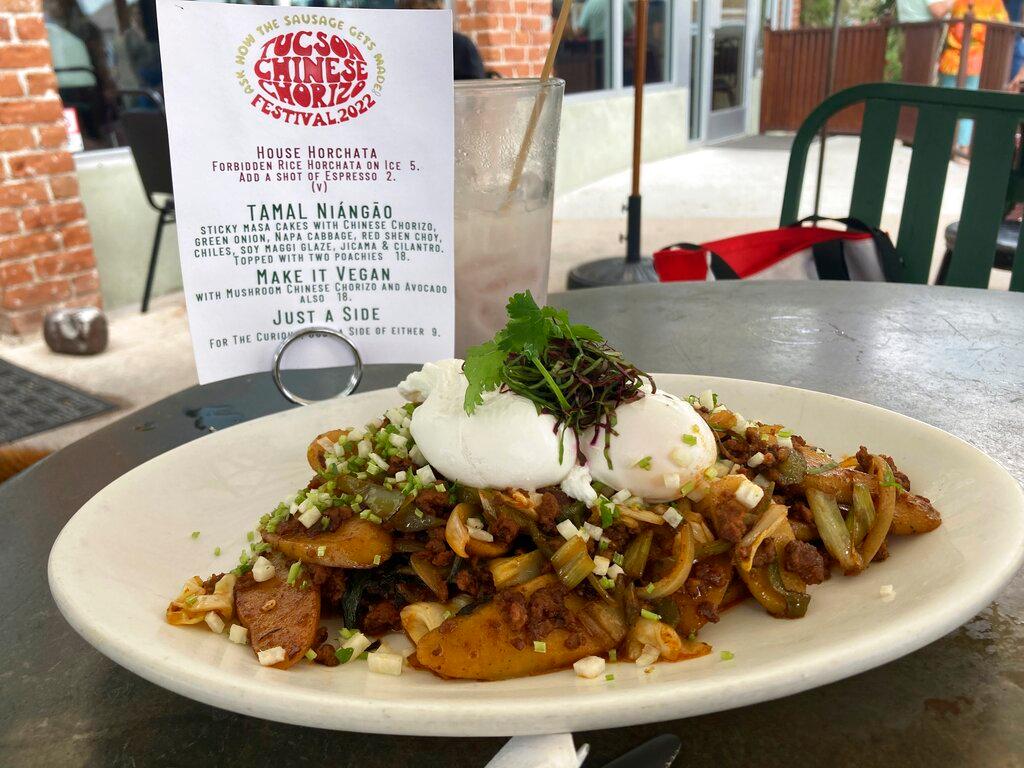 Tamal Niangao, a dish of sticky masa cakes with chorizo, green onion, Napa cabbage and chilies in a soy maggi glaze and topped with jicama, cilantro and two poached eggs is served at 5 Points Market & Restaurant in the Barrio Viejo neighborhood of Tucson, Arizona