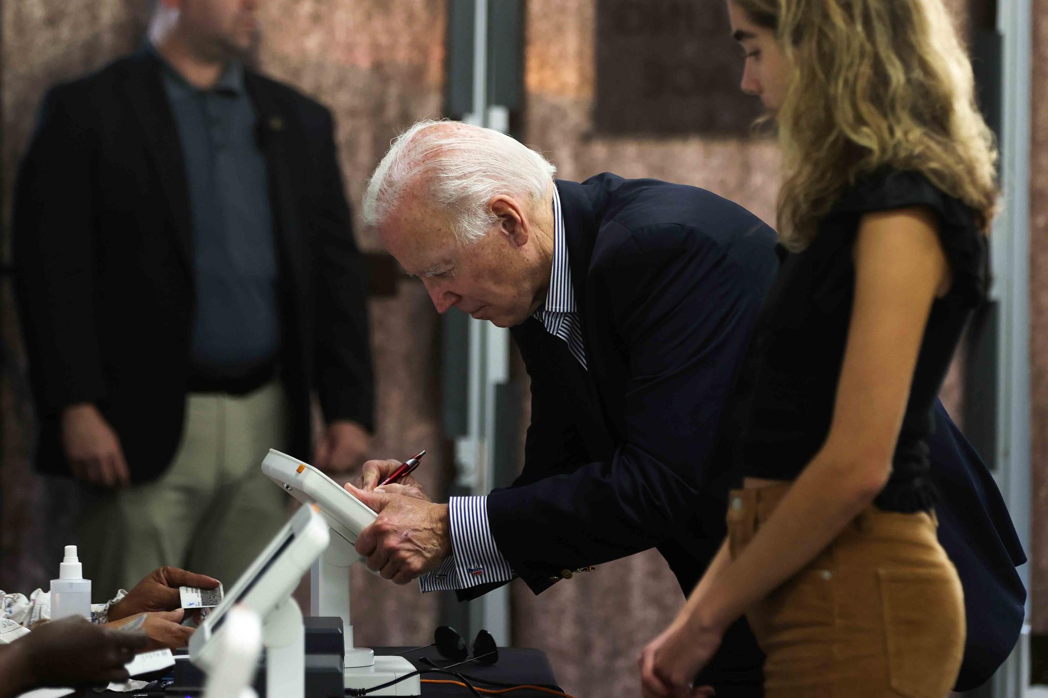 President Joe Biden prepares to cast his vote during early voting for the 2022 U.S. midterm elections with his granddaughter Natalie Biden, a first-time voter, at a polling station in Wilmington, Del., Saturday, Oct. 29, 2022.