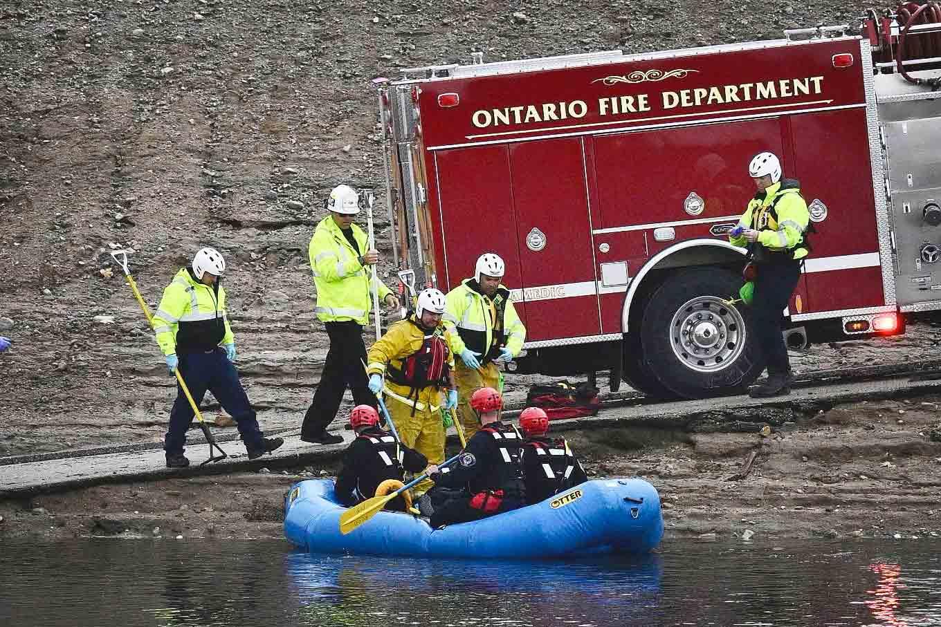 A swift water rescue team from the Ontario Fire Dept. rides in a raft on flood waters in a flood control channel in Ontario, Calif. on Tuesday, Nov. 8, 2022.