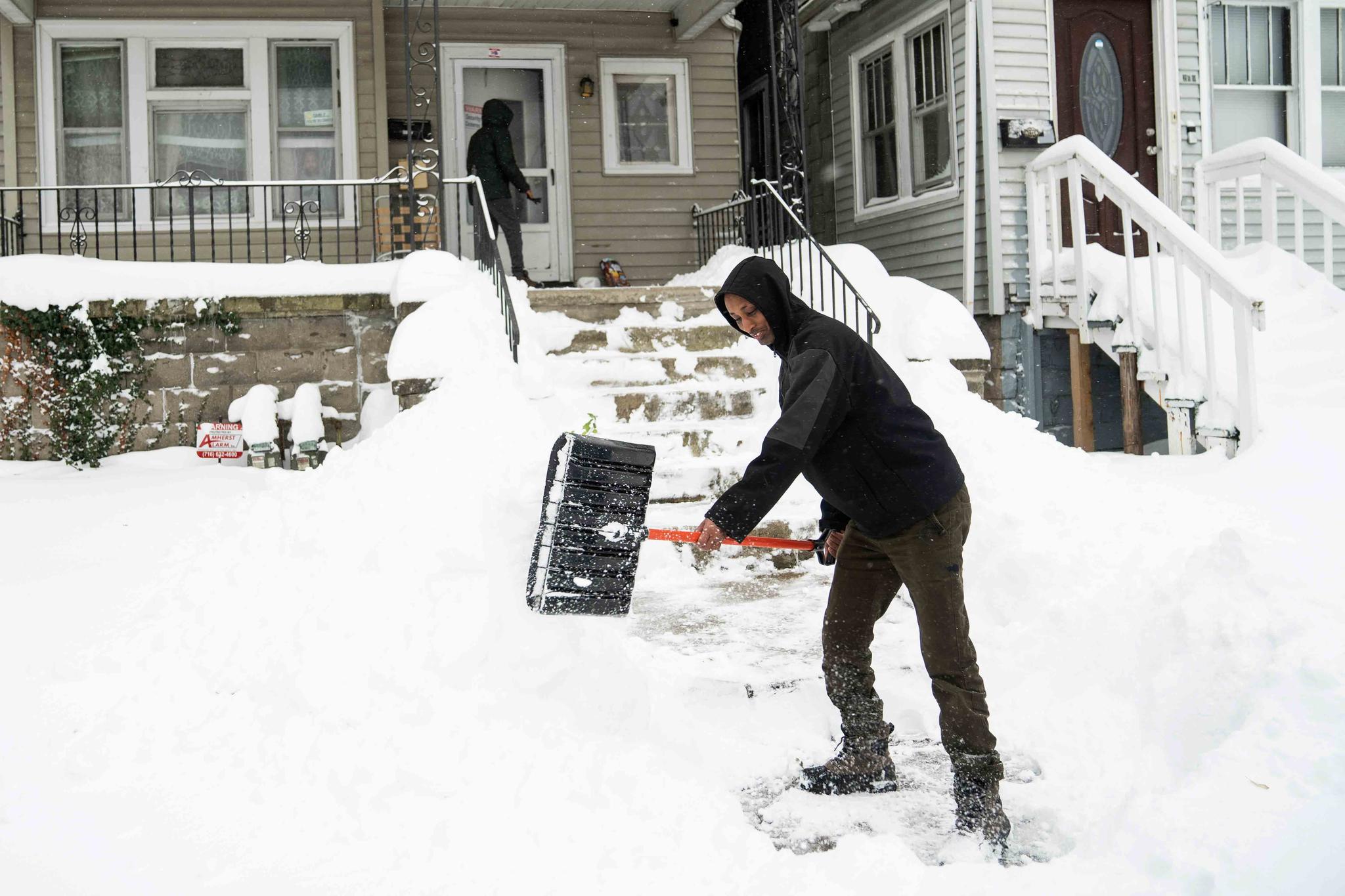 Ahmed Osman shovels his walk on the West Side, Saturday, Nov. 19, 2022 in Buffalo, N.Y.