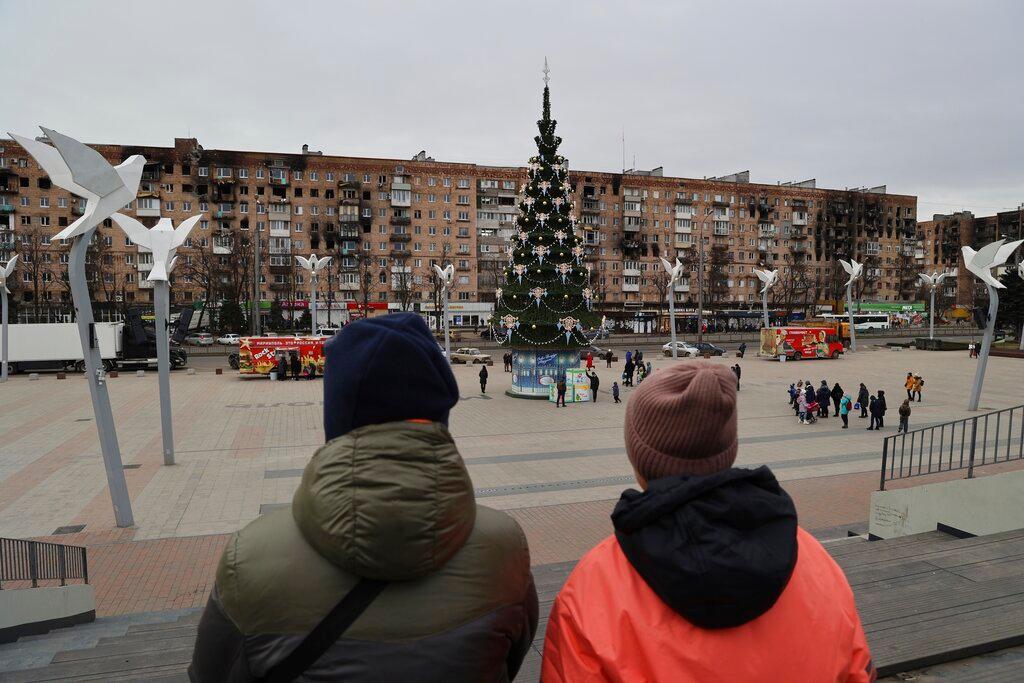 Local citizens walk near a Christmas tree decorated for Orthodox Christmas and the New Year festivities in Mariupol, in Russian-controlled Donetsk region, eastern Ukraine