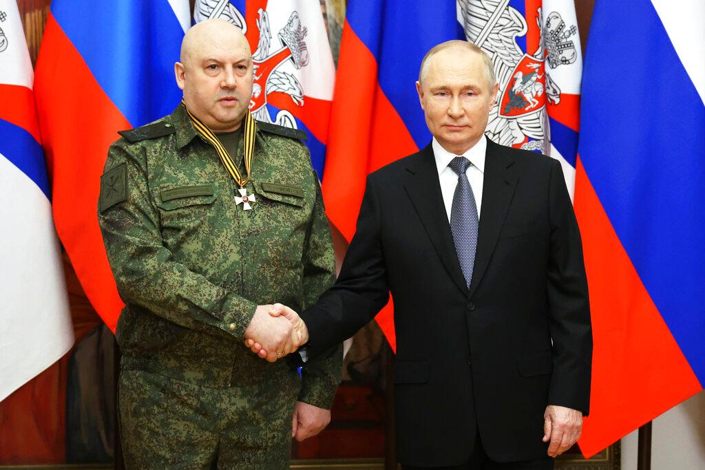 (12/31/22) Russian President Vladimir Putin, right, shakes hands with commander of Russia's military operation in Ukraine General Sergei Surovikin, awarded with order of Saint George of the Third Class