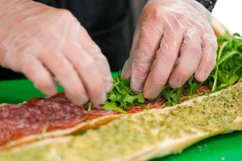 Chef Josh Gjersand prepares a sandwich with homemade pesto aioli and layered with Toscano salami, Monterey Jack and fresh arugula for Mount Diablo High School students to try during a taste test in Concord, Calif.