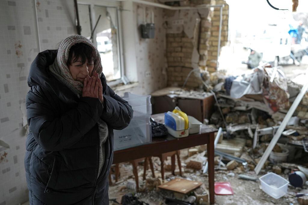 Halina Panasian, 69, reacts inside her destroyed house after a Russian rocket attack in Hlevakha, Kyiv region