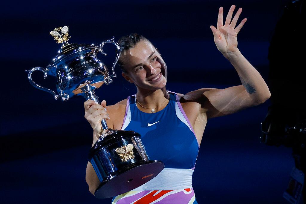 Aryna Sabalenka of Belarus waves as she holds the Daphne Akhurst Memorial Trophy after defeating Elena Rybakina of Kazakhstan in the women's singles final during the women's singles final at the Australian Open tennis championship in Melbourne, Australia, Saturday, Jan. 28, 2023