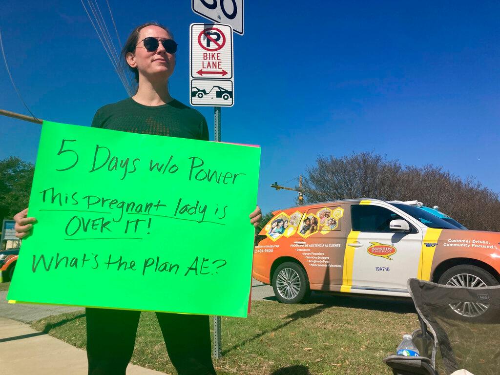 Katy Manganella, 37, protests in front of an Austin Energy truck in her neighborhood in Austin, Texas, Sunday, Feb. 5, 2023. 