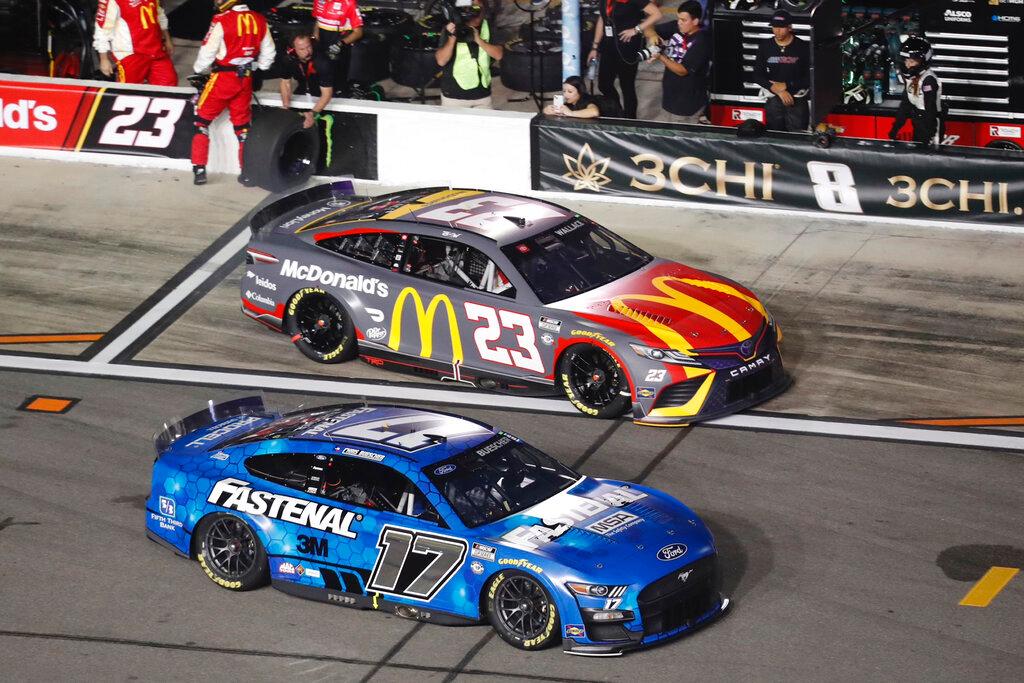 Chris Buescher (17) jumps ahead of Bubba Wallace (23) after a pit stop during the first of two qualifying auto races for the NASCAR Daytona 500 at Daytona International Speedway