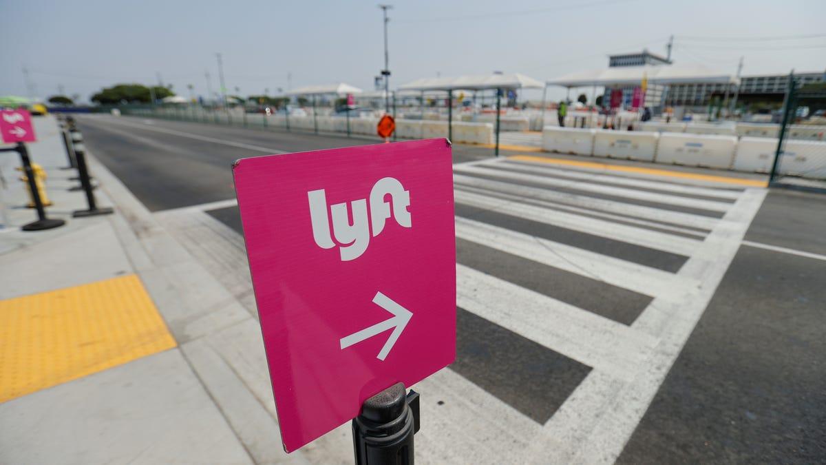 Pink lift sign with an arrow pointing across a street